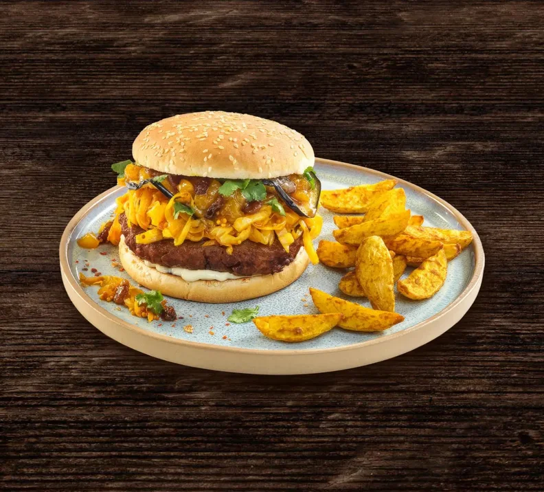 THE GREEN MOUNTAIN Indian Burger mit Kurkuma-Kohl, Aprikosen-Chutney und Auberginen, dazu Curry-Potato-Wedges